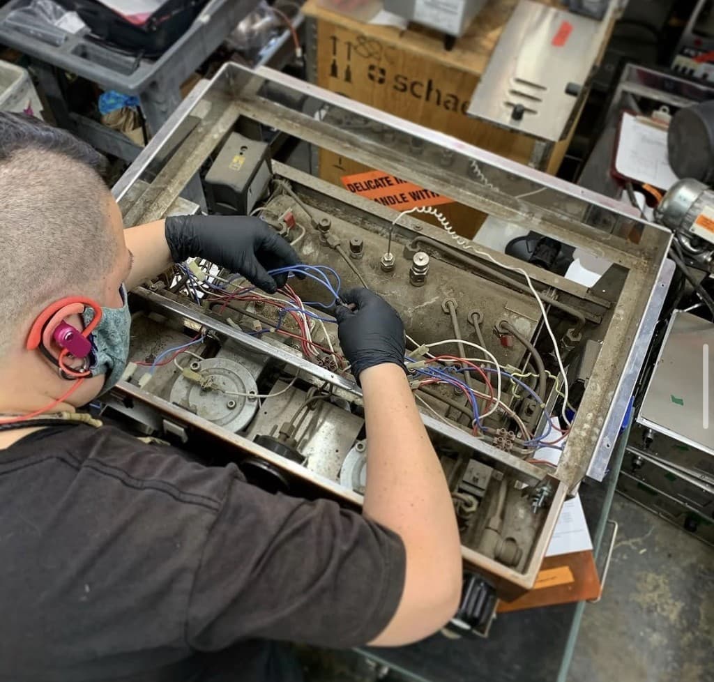 Technician servicing commercial espresso equipment